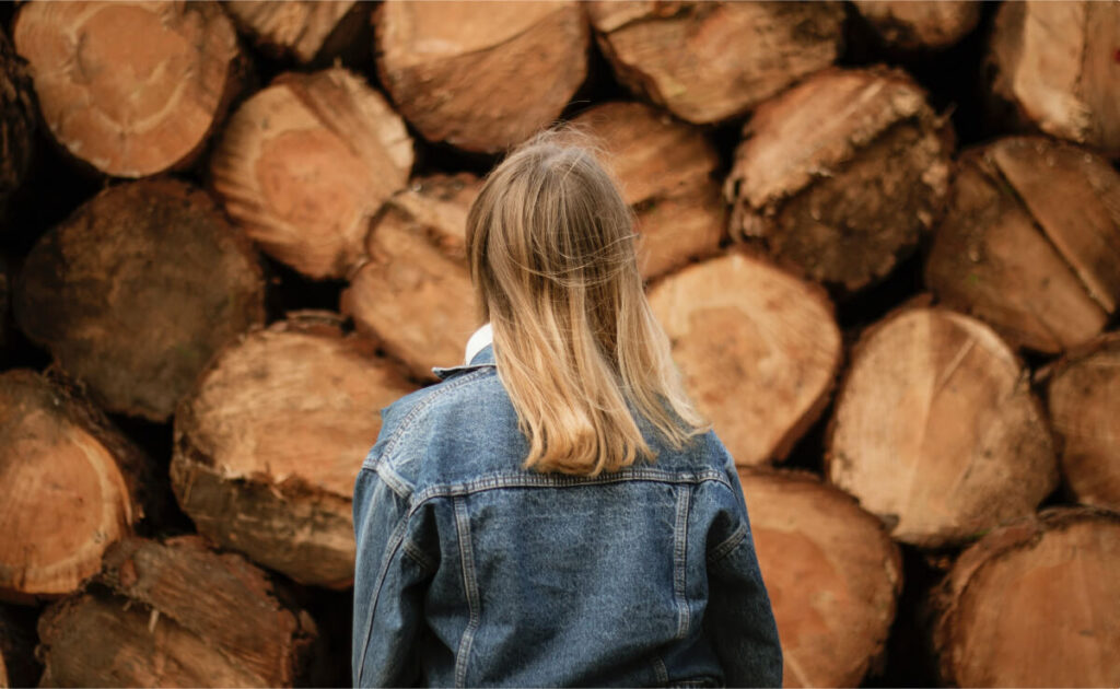 woman in front of logs